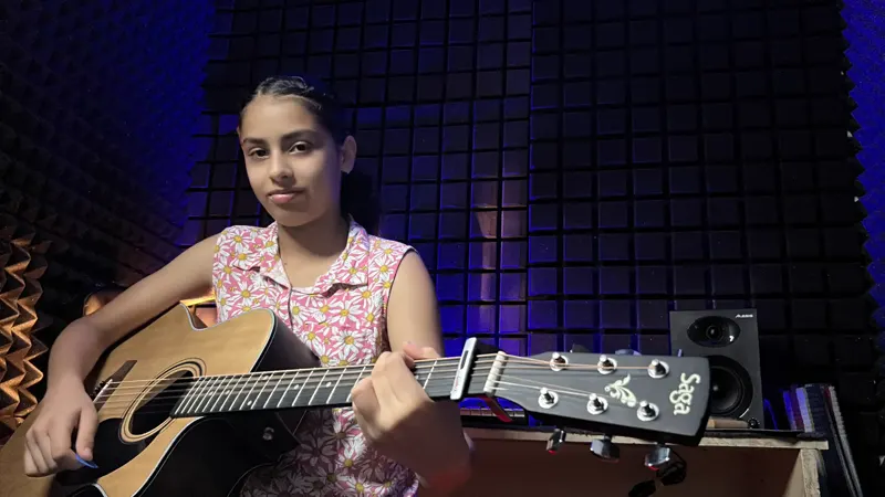 A student practising acoustic guitar at Dwarka School of Music